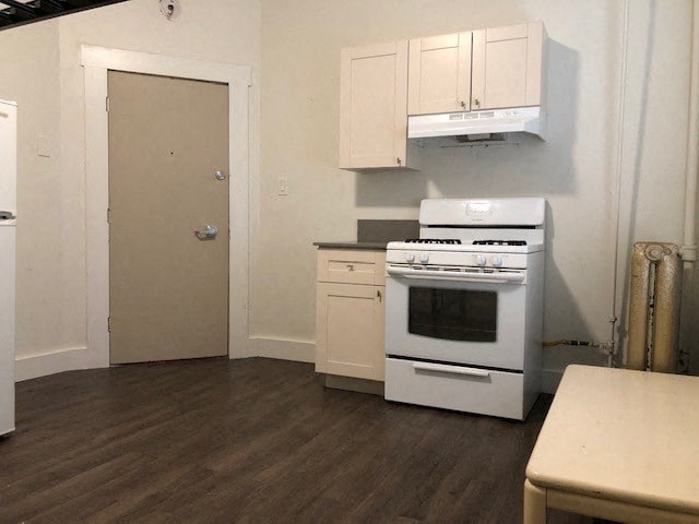 a kitchen with a stove and white cabinets