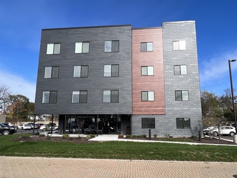 A modern building with a grey and pink facade.