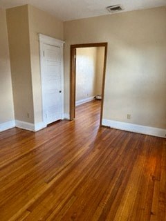 an empty living room with wood floors and a doorway