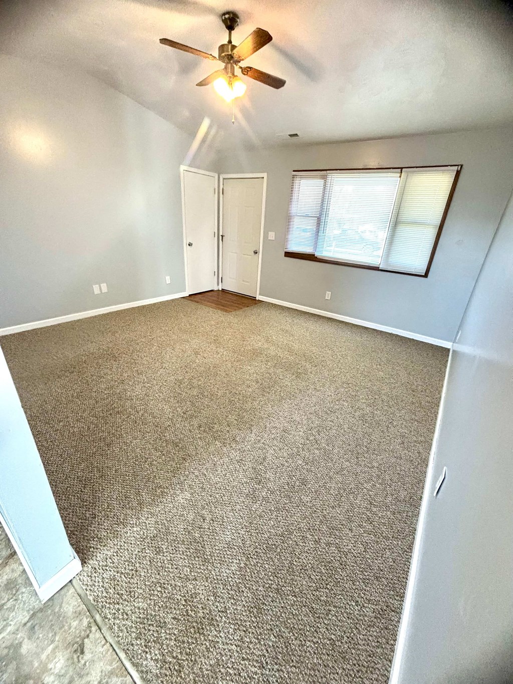 a room with a carpeted floor and a ceiling fan