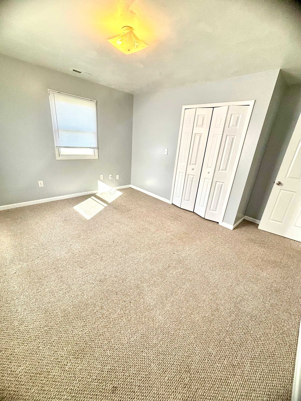 an empty room with a carpeted floor and a window
