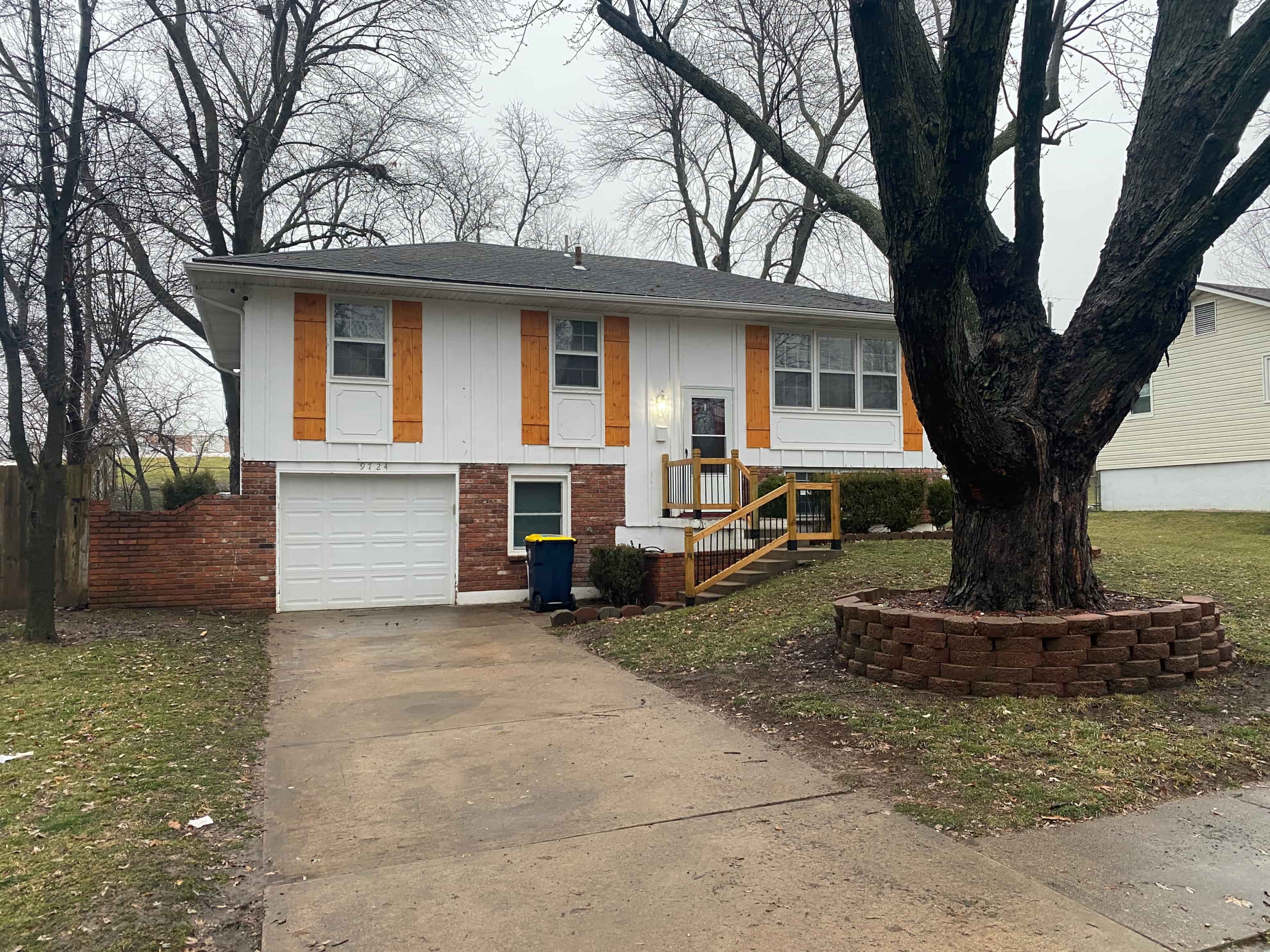 a white house with a large tree in front of it