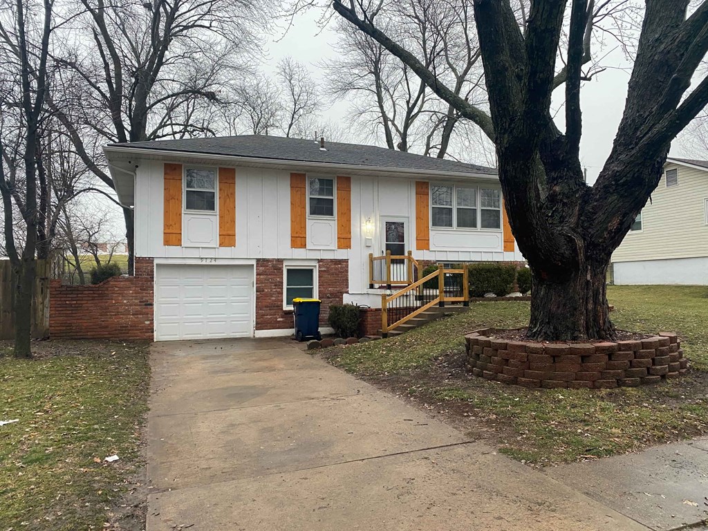 a white house with a large tree in front of it