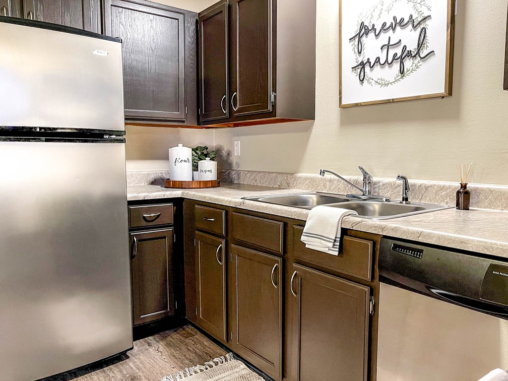 a kitchen with stainless steel appliances and wooden cabinets
