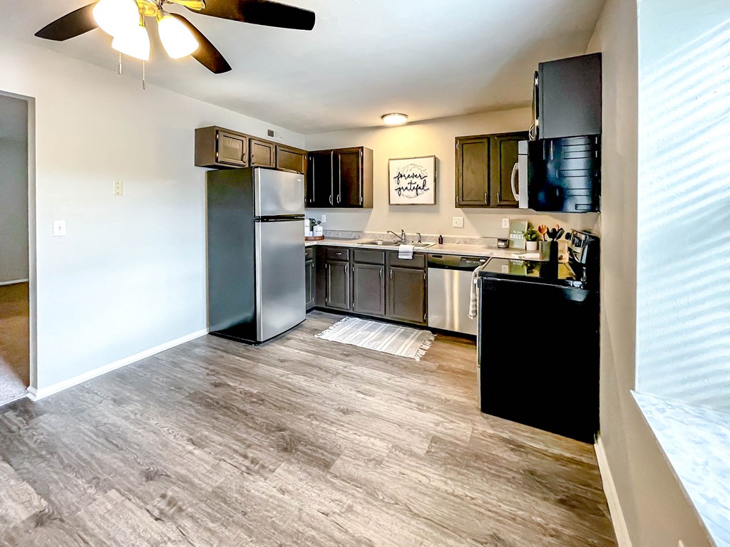 a kitchen with stainless steel appliances and a wooden floor