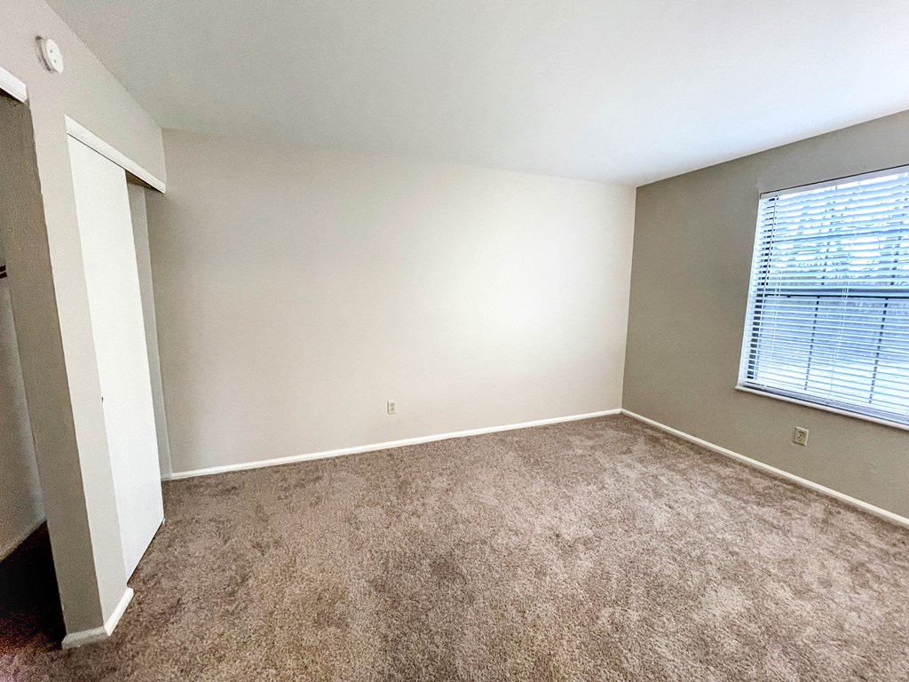 an empty room with carpet and a window