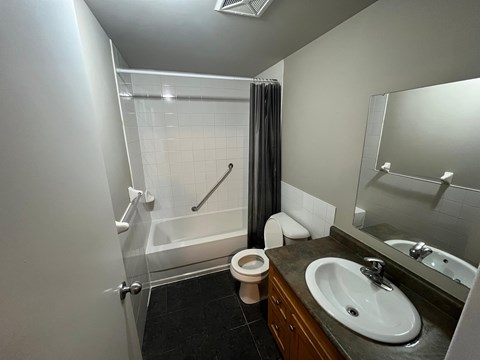 A bathroom with a toilet, sink, and shower.