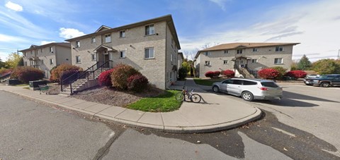 A street view of a residential area with a car parked on the side of the road.