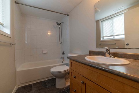 A bathroom with a toilet, sink, and bathtub.