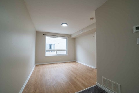 A room with a window and wooden flooring.