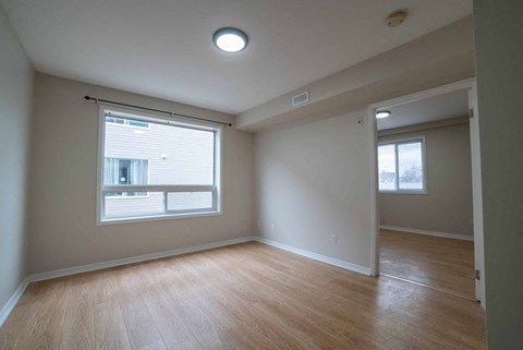 A room with a window and wooden flooring.