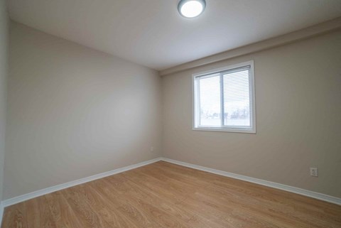 A room with a window and wooden flooring.