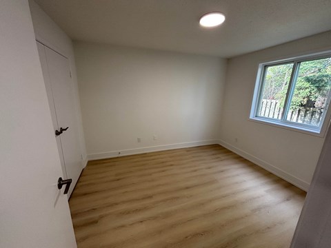A room with a wooden floor and a window.