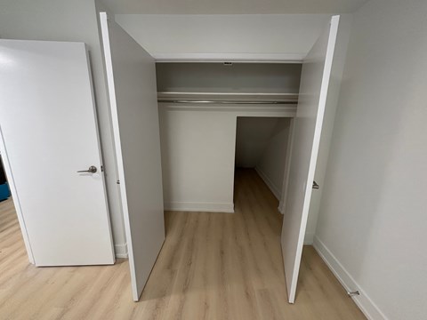 A white door is open to a room with a white ceiling and a white wall.