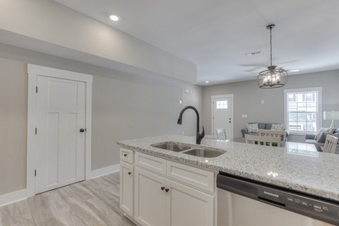 the kitchen and living room in a new home with white cabinets