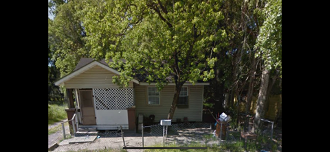 a small house with a tree in front of it