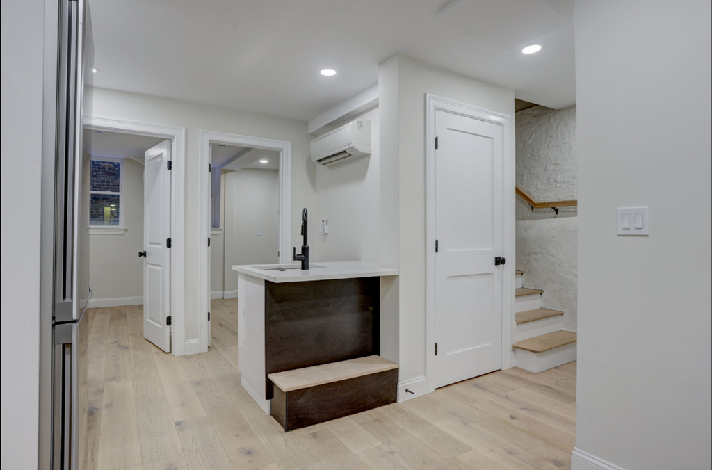 a white bathroom with a sink and a staircase