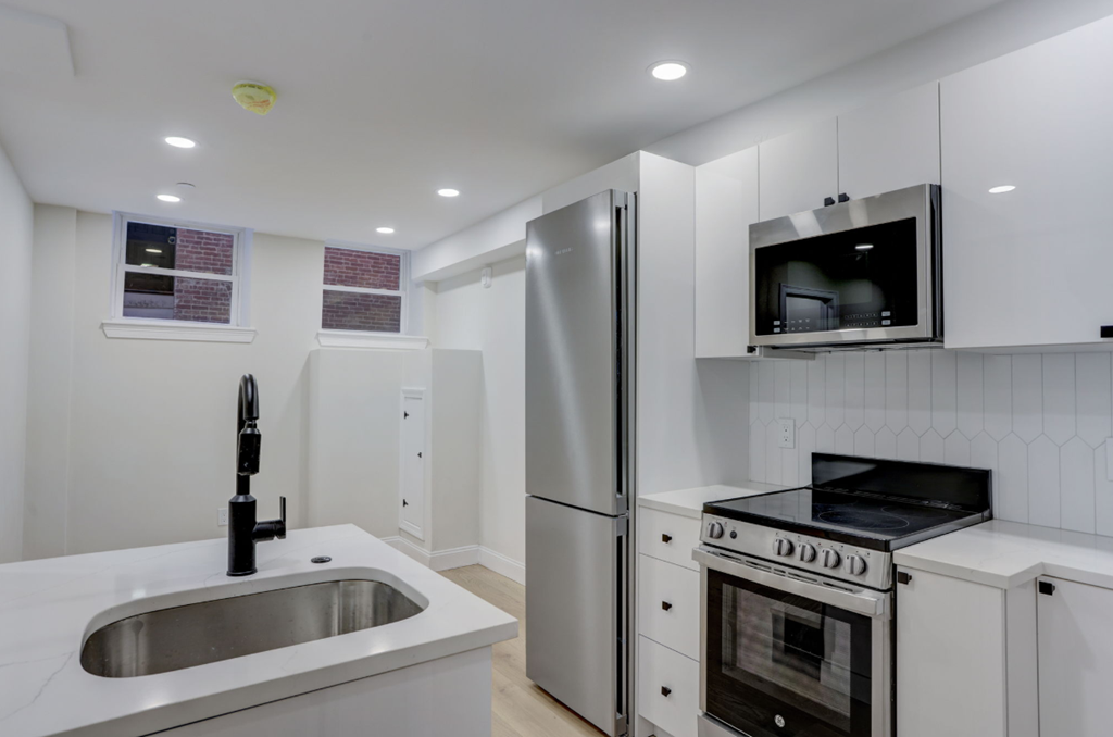 a kitchen with white cabinets and stainless steel appliances