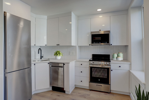 a kitchen with white cabinets and stainless steel appliances