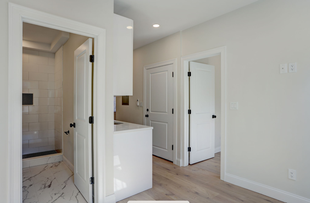 a kitchen with white cabinets and a white counter top and white doors