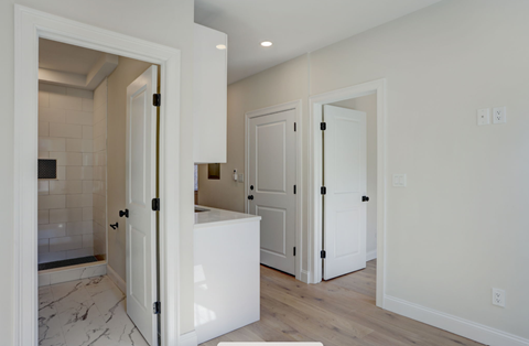 a kitchen with white cabinets and a white counter top and white doors