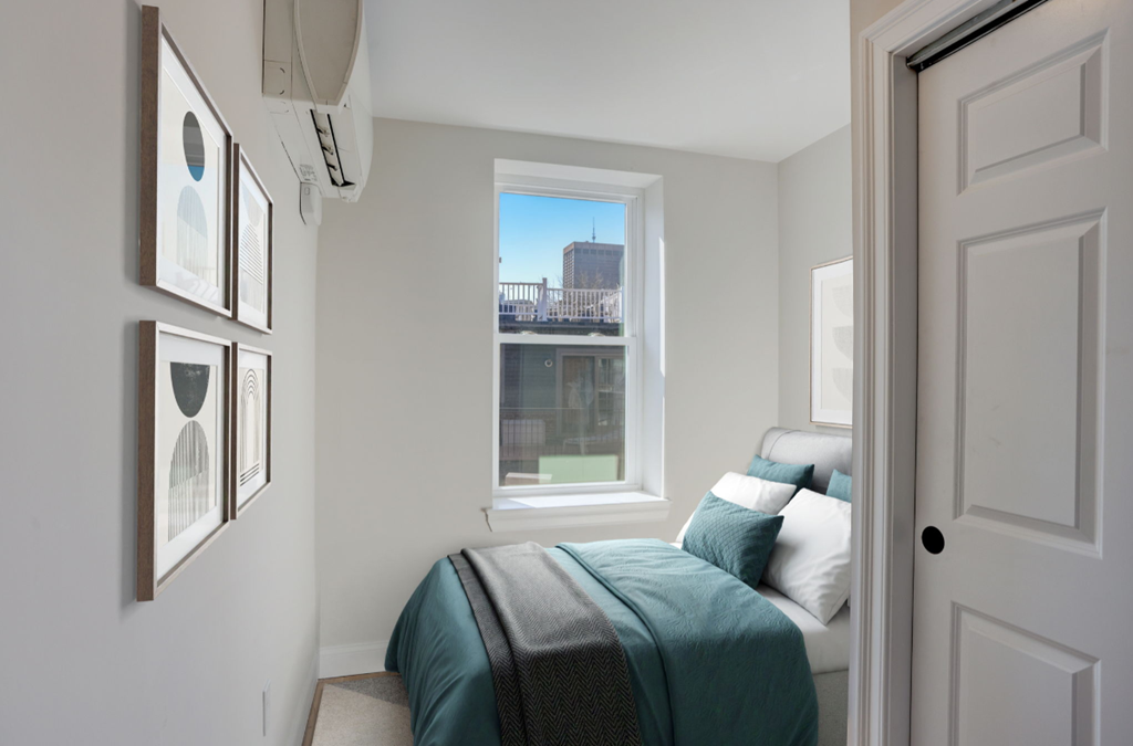 a small bedroom with a bed and a window