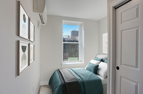 a small bedroom with a bed and a window