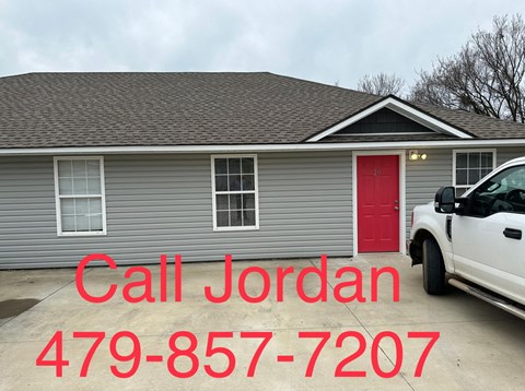 a mobile home with a red door and a truck parked in front of it