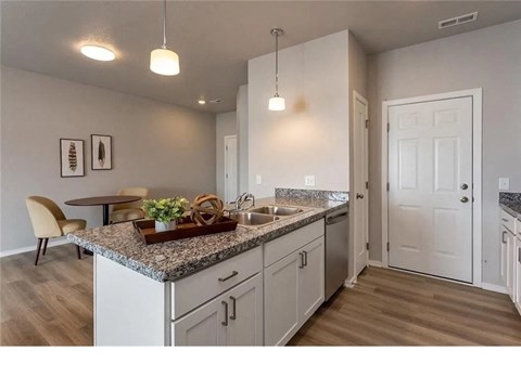 A kitchen with a granite countertop and white cabinets.