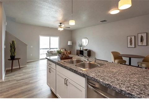 A kitchen with a granite countertop and white cabinets.