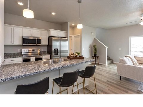 A kitchen with granite countertops and a breakfast bar.