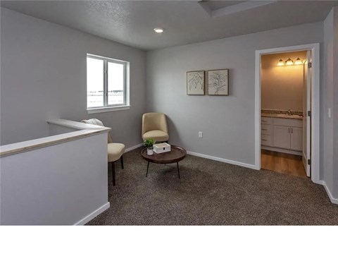 A room with a chair and a table in it.