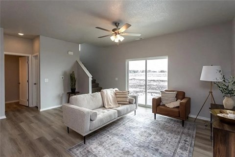 A living room with a white couch and a brown armchair.