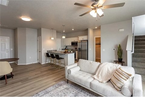 A living room with a couch, chairs, and a dining table.