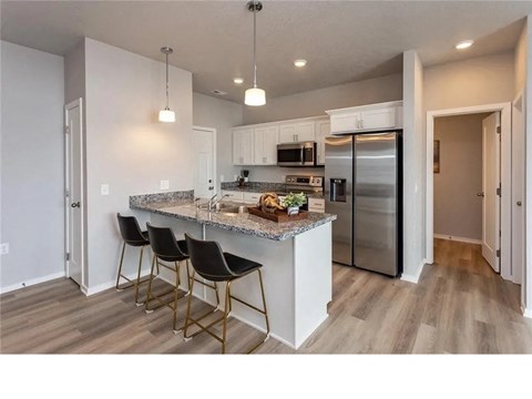 A kitchen with a granite countertop and a refrigerator.