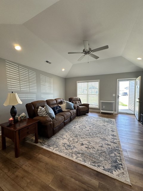 a living room with a couch and a ceiling fan
