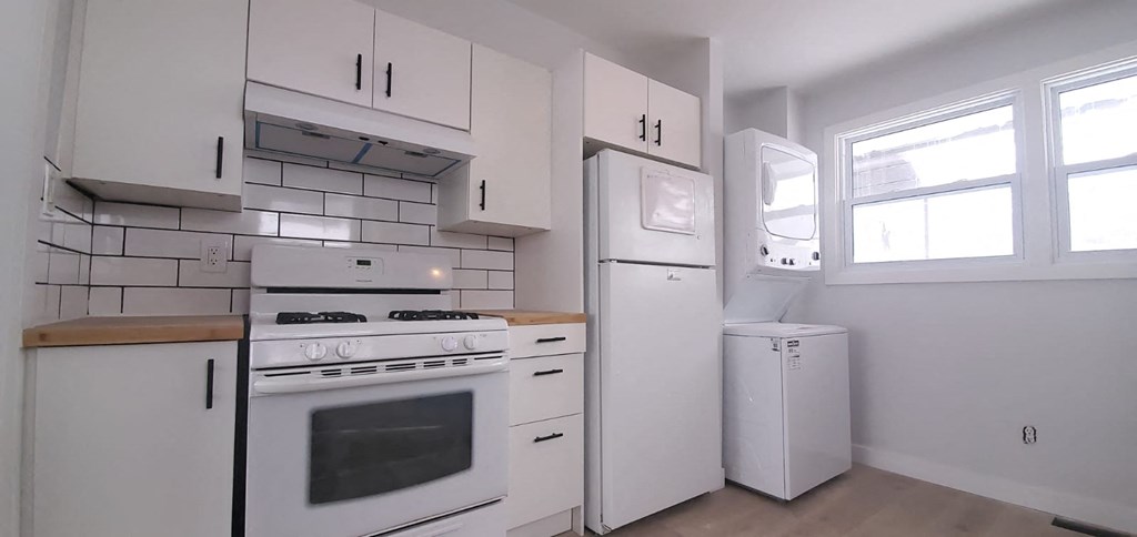 a kitchen with white appliances and white cabinets