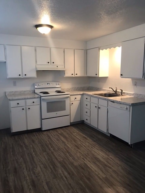 A kitchen with white cabinets and a stove top oven.