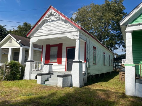A white house with red trim and a red door.
