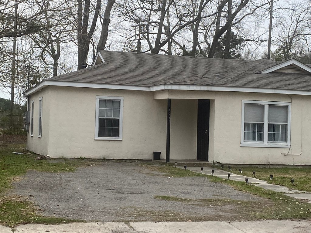 A small house with a grey roof and white walls.