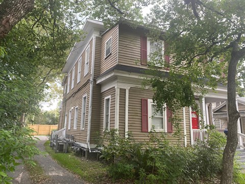 A two-story house with a red door and red shutters.