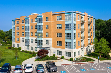 A large multi-story building with a parking lot in front.