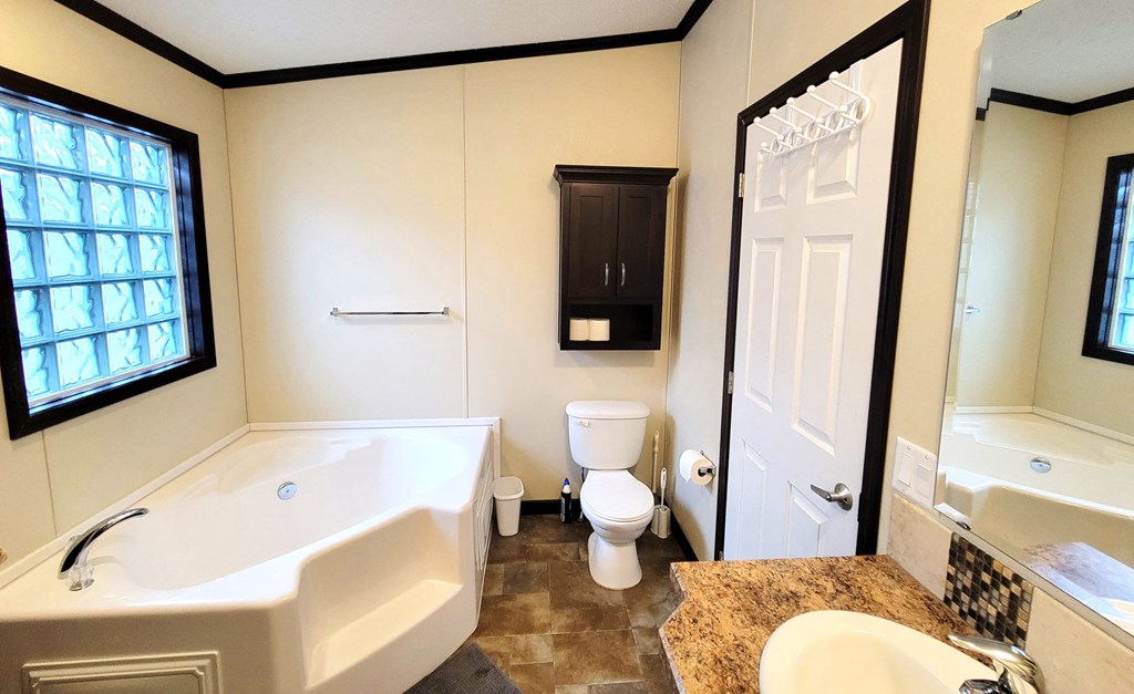 a bathroom with a tub and a sink and a toilet