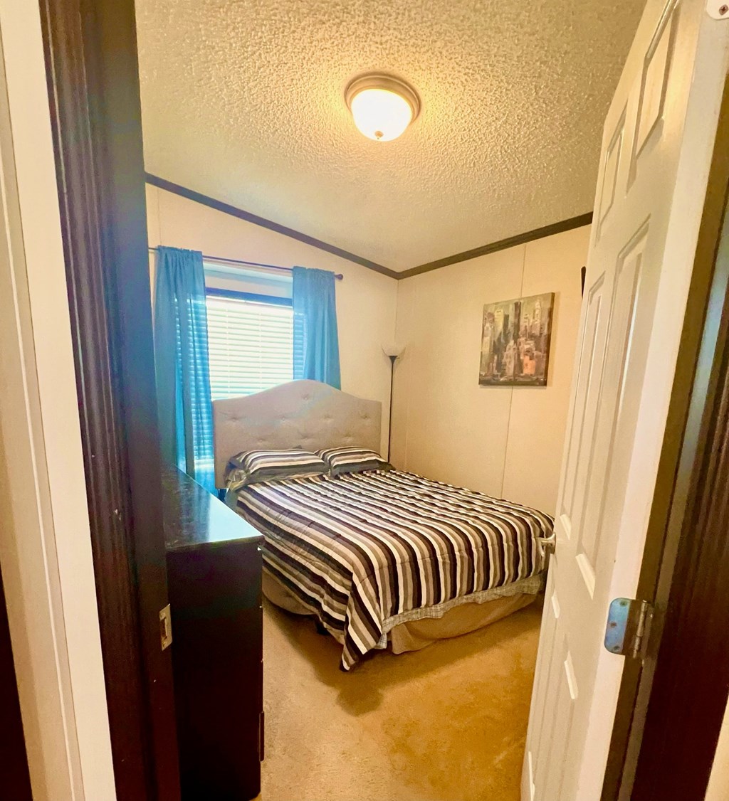 a small bedroom with a bed and a window