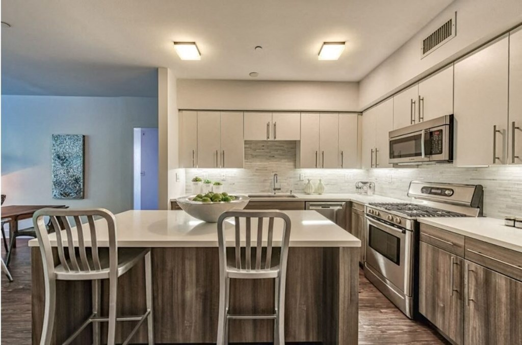 a kitchen with a large island with two chairs