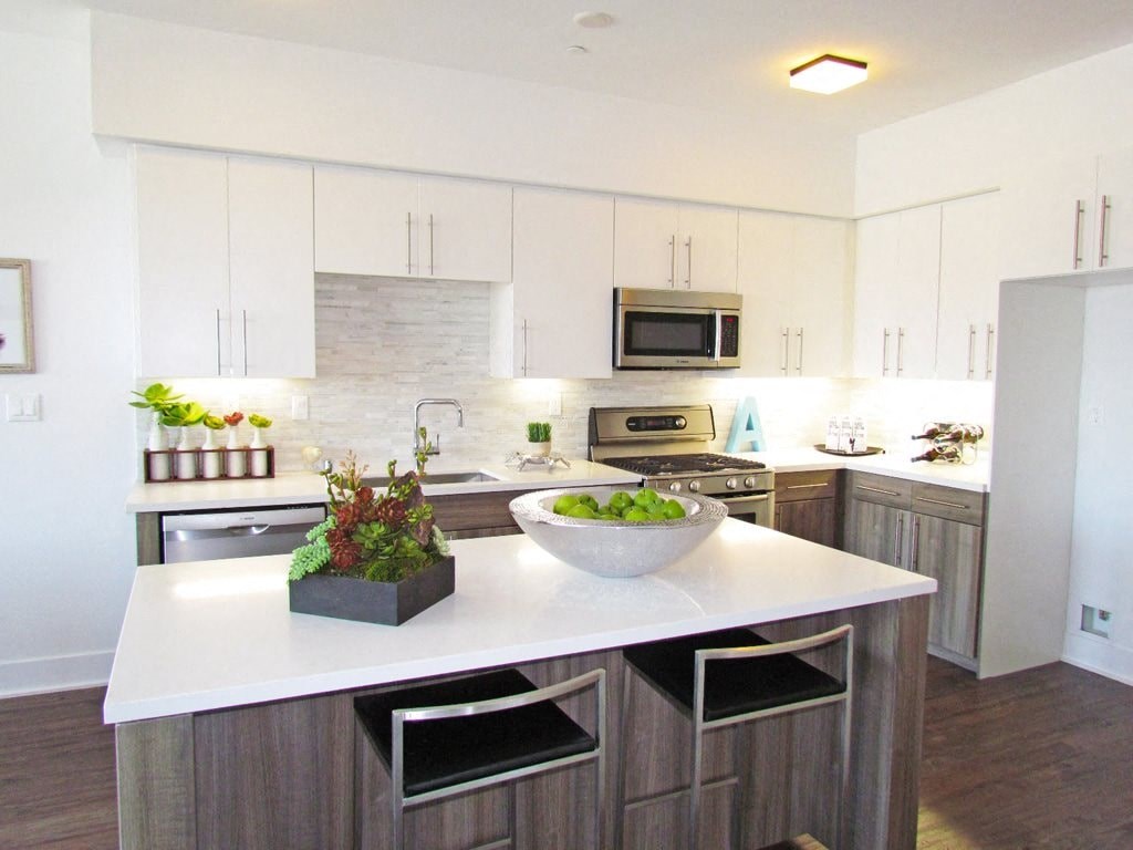a large kitchen with a white counter top and a sink