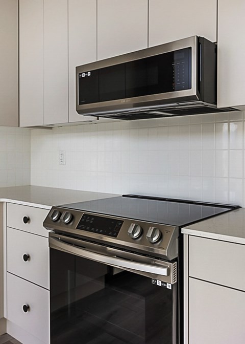 a kitchen with a stove and a microwave above it