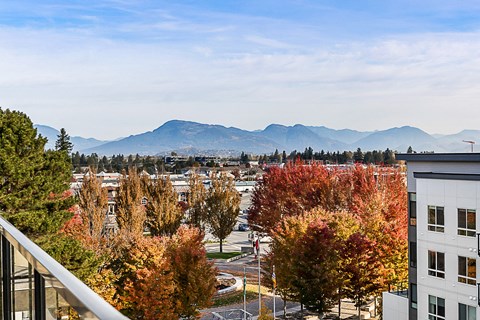 a view of the city and mountains from the balcony of a apartment building