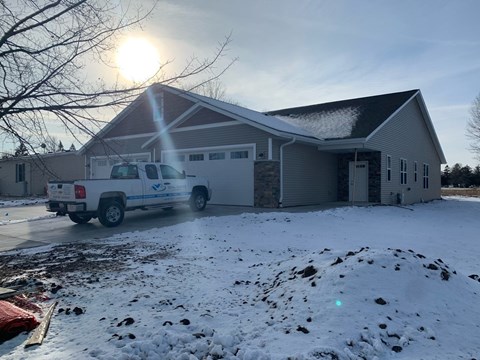 a house with a truck parked outside in the snow