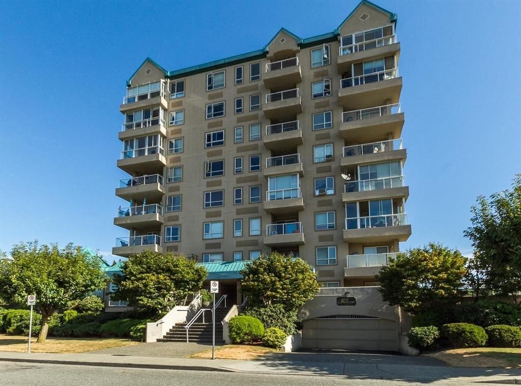 A large apartment building with a green roof and a staircase leading to the entrance.